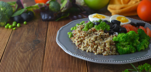 Layered vegetable salad with quinoa, green peas, broccoli, olives, red onion. Healthy food take away. Banner.