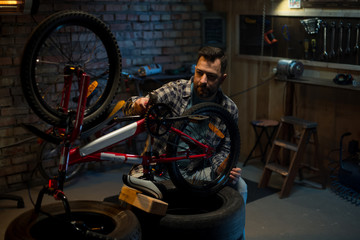 Fototapeta na wymiar Man working in a bicycle repair shop alone