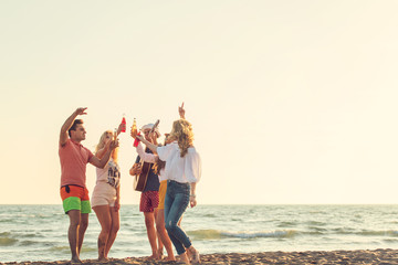 Group of friends on the beach play