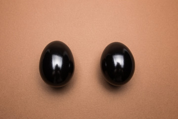 Black eggs on brown background close up
