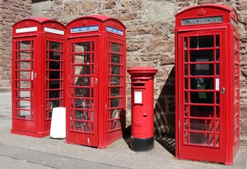 Drei rote Telefon Boxen (Zellen) und ein Briefkasten.