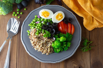 Colorful quinoa buddha plate withbroccoli, egg, spring onion, tomatoes and green peas. Home made food. Concept for a tasty and healthy vegetarian meal. Top view. Copy space.