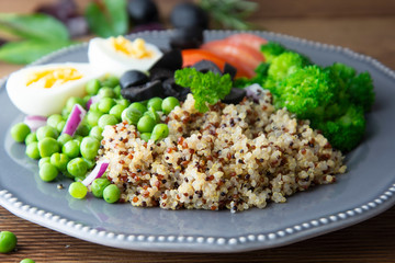 Colorful quinoa buddha plate withbroccoli, egg, spring onion, tomatoes and green peas. Home made food. Concept for a tasty and healthy vegetarian meal. Top view. Copy space.