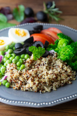 Colorful quinoa buddha plate withbroccoli, egg, spring onion, tomatoes and green peas. Home made food. Concept for a tasty and healthy vegetarian meal. Top view. Copy space.