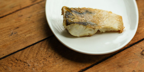 Fish, fried seafood (white fish on the plate). Food background