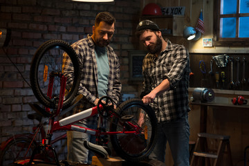 Two men working in a bicycle repair shop