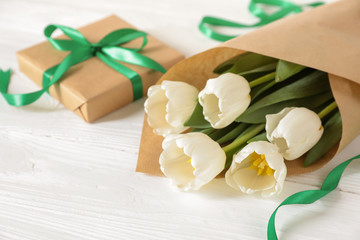 White tulips bouquet and gift box, copy space on white wooden background, spring holidays gift concept.