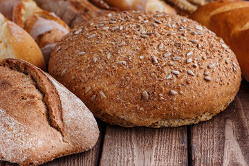 Assortment of baked bread on wooden table background