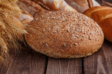 Assortment of baked bread on wooden table background
