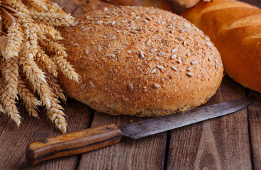 Assortment of baked bread on wooden table background