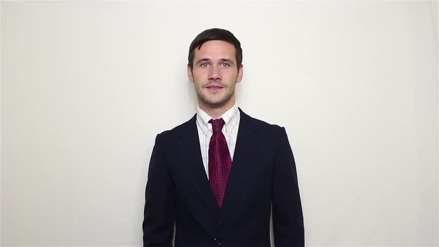 Young beautiful businessman in blue suit smiling and waving her hand greeting customers.Portrait on a white background.