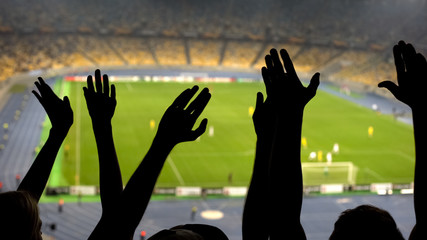 Plakat Hands of football fans, cheering team during match on overcrowded stadium