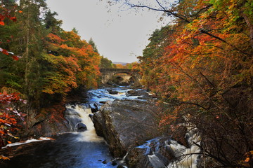 Wasserfall Invermoriston Falls Schottland im Herbst mit Langzeitbelichtung und Steinbrücke mit Fluss