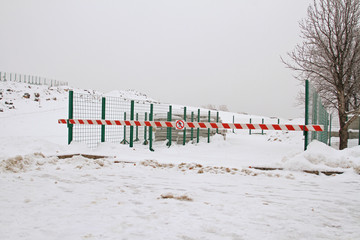 Closed storage area with building concrete slabs, covered with a barrier with a table "No entry"