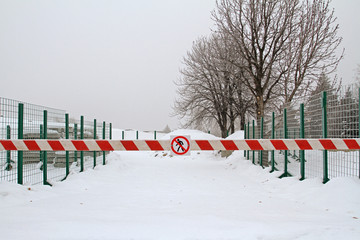 Closed storage area with building concrete slabs, covered with a barrier with a table "No entry"