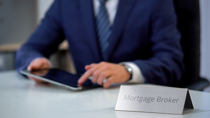 Professional mortgage broker using tablet pc, searching loan offers for client