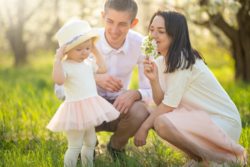 Obraz premium Family on vacation in the park, the sun, a pleasant summer spring mood. Relaxing in the park and walking radar with a child