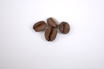 Vier Kaffeebohnen - Nahaufnahme vor weißem Hintergrund