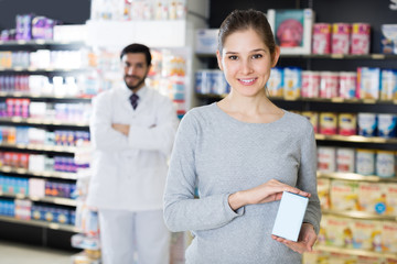 girl  is satisfied the purchase in pharmacy.