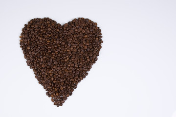 Herz aus Kaffeebohnen vor weißem Hintergrund