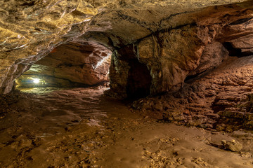View inside the ancient cave with stone walls with additional lighting. Texture of a stone wall in a cave.