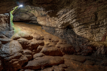 View inside the ancient cave with stone walls with additional lighting. Texture of a stone wall in a cave.