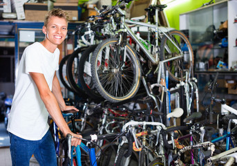 Fototapeta na wymiar Male standing near the cycle in the shop