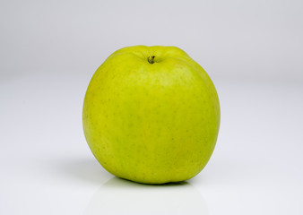 Apfel in der Mitte des Fotos vor grauem Hintergrund