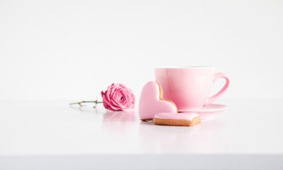 Cup of coffee, rose flower and biscuits in shape of heart on white background. Valentine heart cookies, copy space
