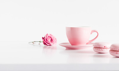 Cup of coffee, rose flower and macaroons on white background, copy space