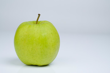 Grüner Apfel vor hellem Untergrund