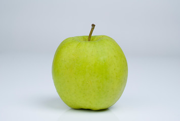 Grüner Apfel vor grauem Hintergrund