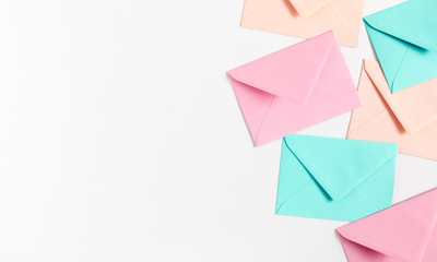 Different colored envelopes on white background. Flat lay, top view, copy space