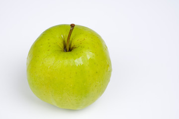 Nasser grüner Apfel vor weißem Hintergrund