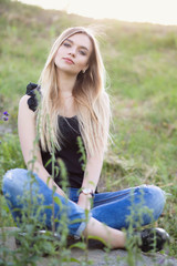 Obraz premium Beautiful woman posing sitting on a stone.