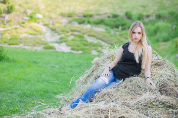 Nice lady posing sitting on the hay.