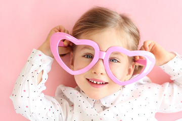 Little girl with heart glasses.