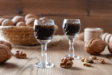 Two glasses of homemade nut liqueur with walnuts