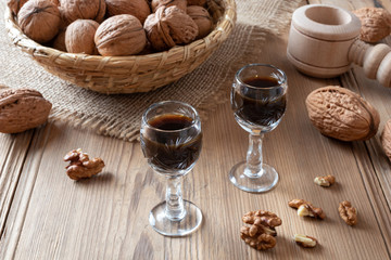 Fototapeta na wymiar Two glasses of homemade nut liqueur with walnuts