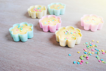 Dough is poured into baking tin. Rows of colorful cups. Muffins preparation at home.