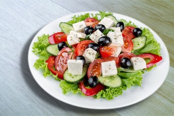 Greek salad with fresh vegetables on background