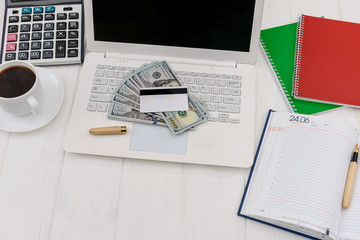 Dollars with laptop and diary top view