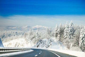 Highway road in winter, mountains covered with snow in Gorski kotar, Croatia  in background