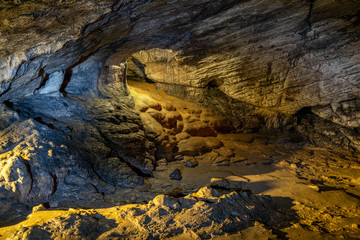 View inside the ancient cave with stone walls with additional lighting. Texture of a stone wall in a cave.