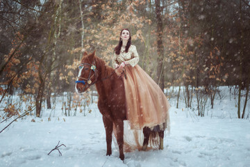 Fototapeta na wymiar Woman riding a horse in the winter forest.