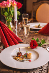 baked chicken wings with scallop and sauce served on white plate, romantic evening with delicios food on valentines day 