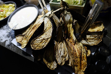 Grilled eggplants cut in half on a table for a catering, top view.