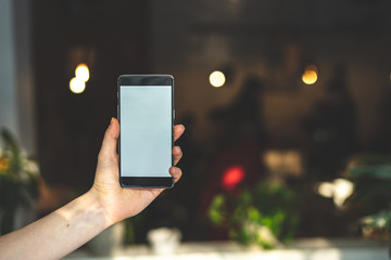 Woman holding cellular in hands against blurred background