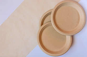 Stack of natural plant paper plates on paper background. Plastic free concept. Copy space
