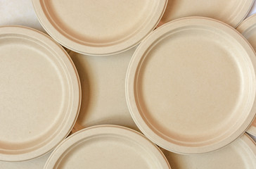 Stack of natural plant paper plates on seamless background. Plastic free concept. Copy space